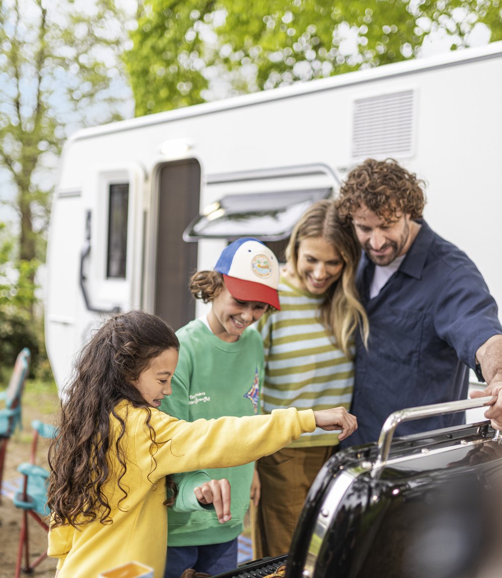 Familie beim Grillen vor einem Fendt-Caravan BIANCO